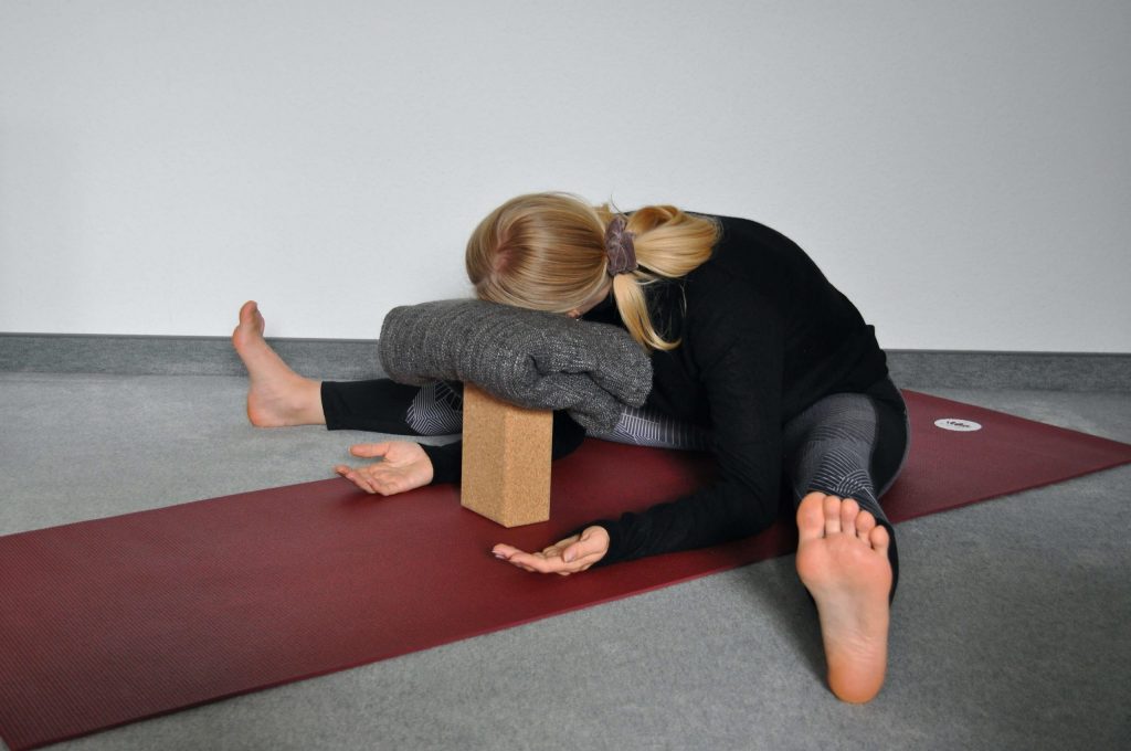 Wide-legged forward bend with forearms on ground
