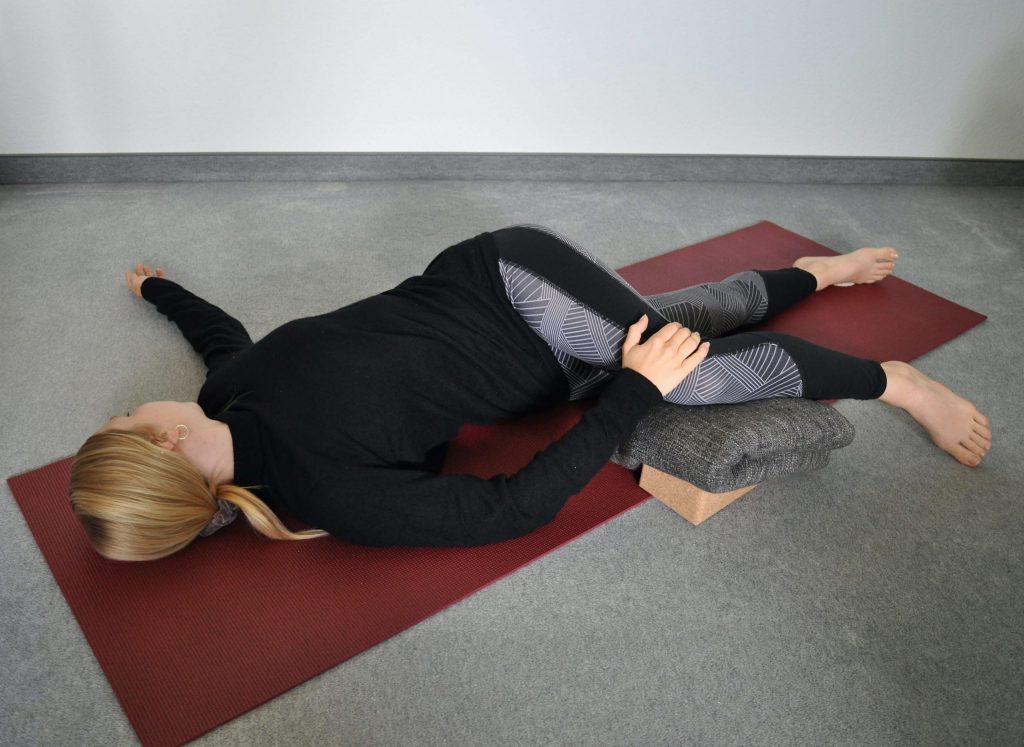 Supine spinal twist yoga pose period relief